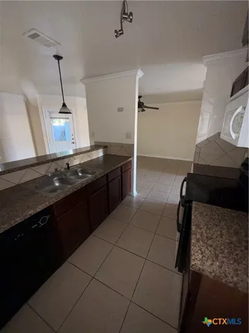 a kitchen with granite countertop a stove and a refrigerator
