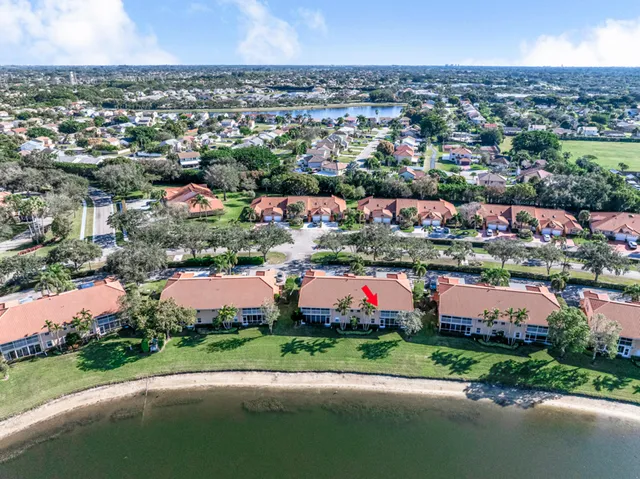 an aerial view of a house with a yard and lake view