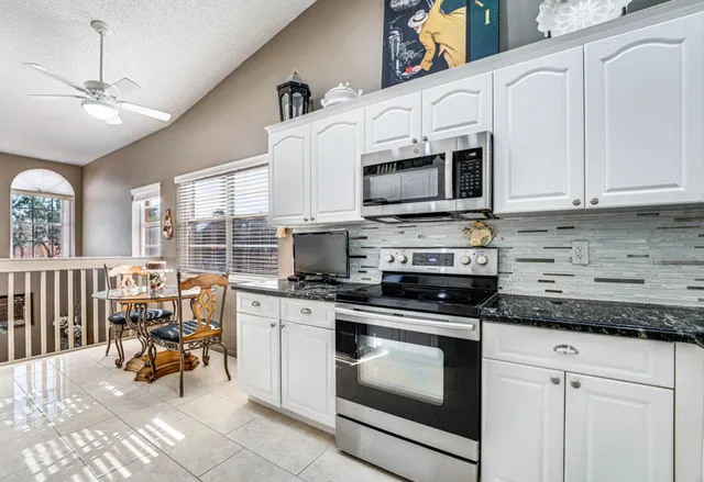 a kitchen with stainless steel appliances kitchen island granite countertop a refrigerator and a stove top oven