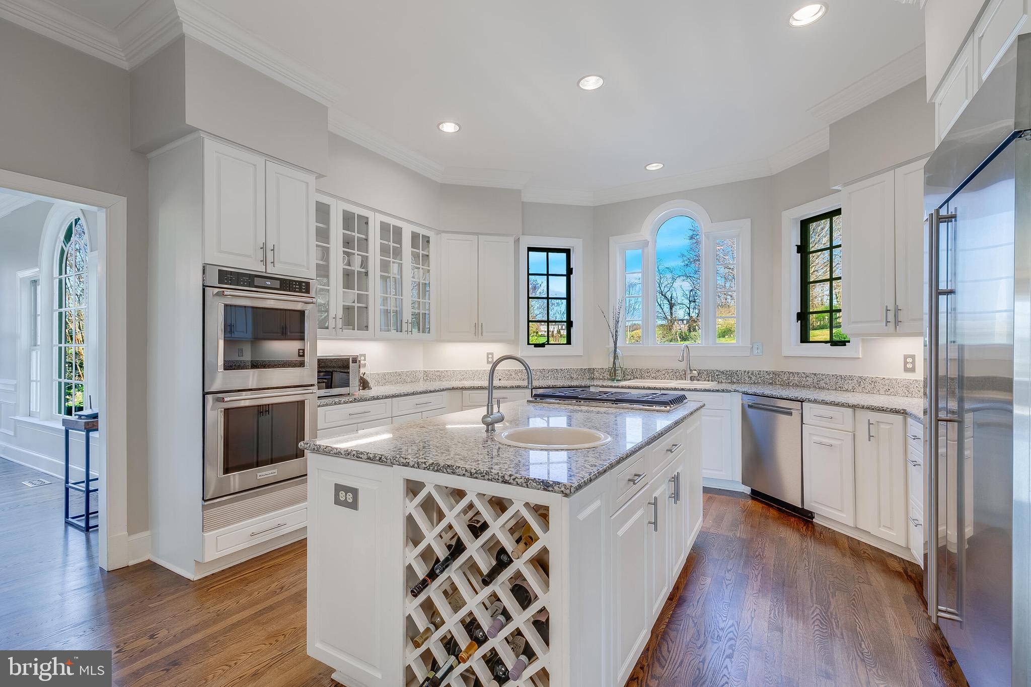 15140 Loyalty Road Waterford, VA 20197 - Photo 16 of 60 a kitchen with stainless steel appliances granite countertop a kitchen island hardwood floor sink stove and microwave