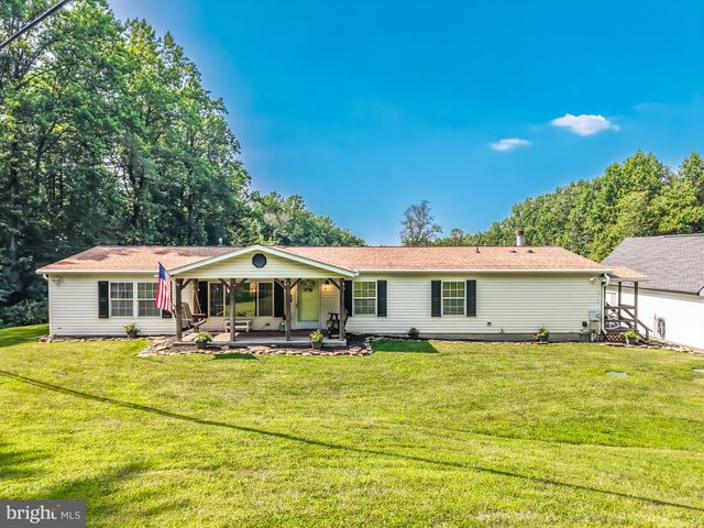 a front view of house with yard and trees around