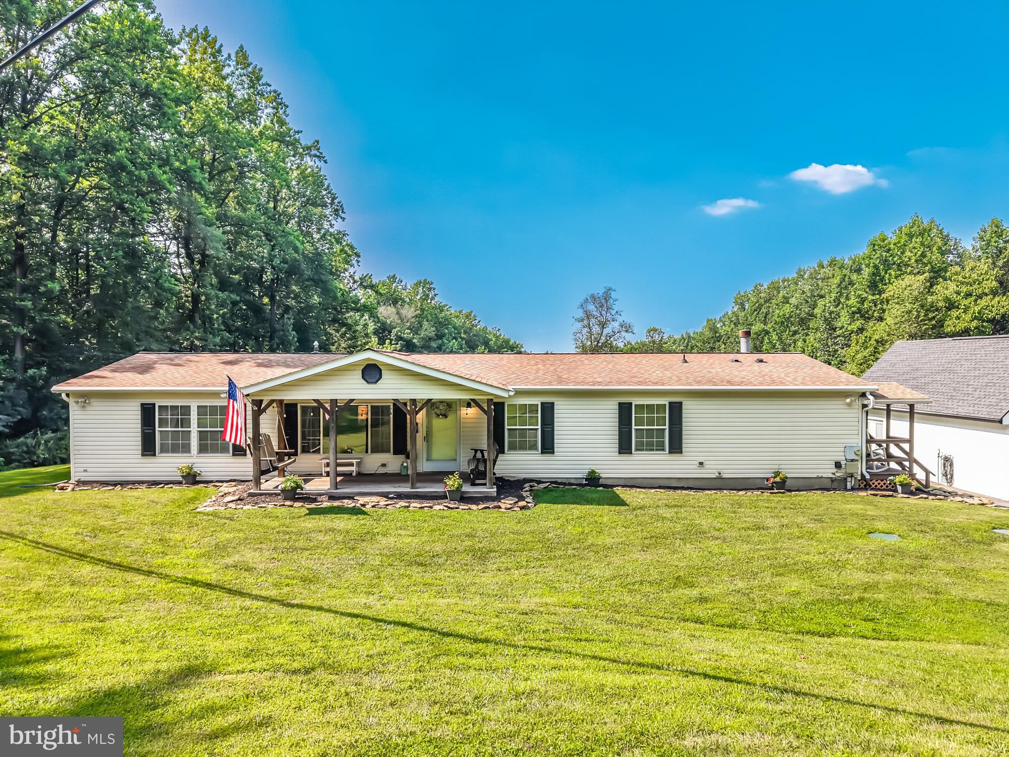 a front view of house with yard and trees around