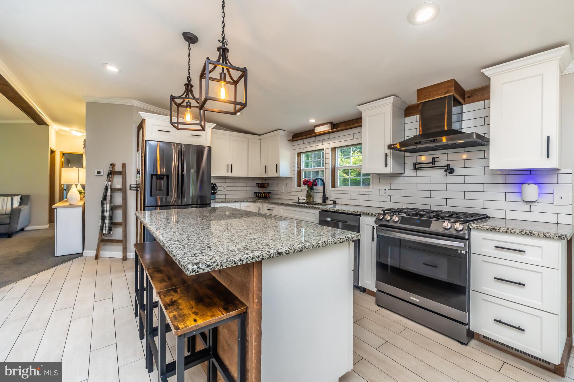 239 Quarry Road Gap, PA 17527 - Photo 3 of 48 a kitchen with stainless steel appliances granite countertop a stove top oven a sink dishwasher a dining table and chairs with wooden floor