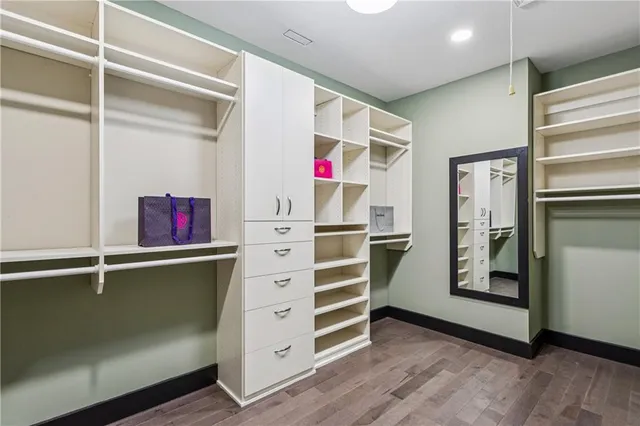 a view of walk in closet with clothes and shoes