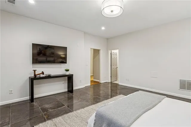 a bedroom with a bed and a flat screen tv