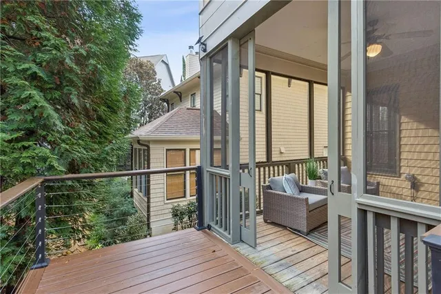 a balcony with wooden floor table and chairs