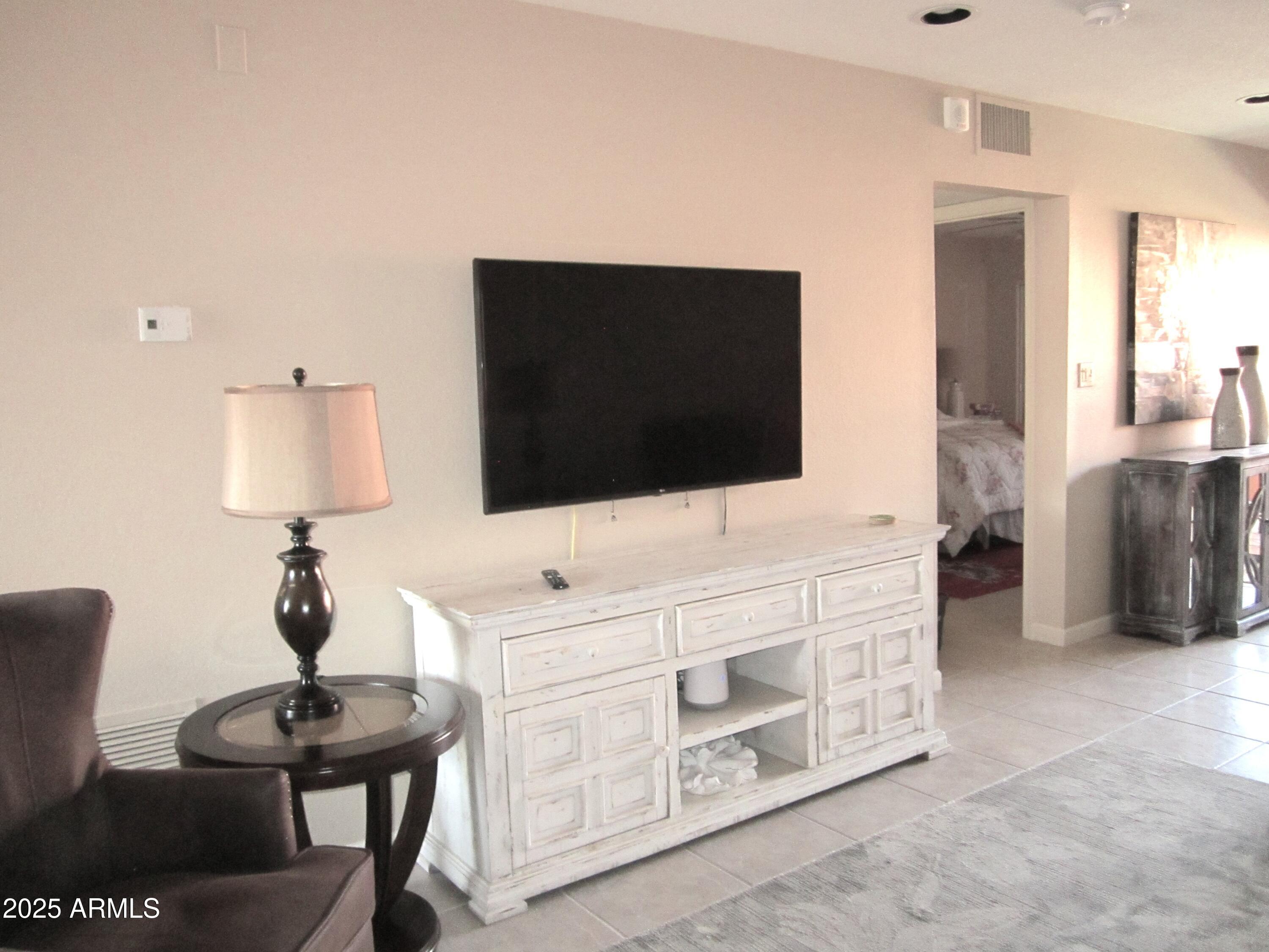 12222 North Paradise Village Parkway West, Unit 325 Phoenix, AZ 85032 - Photo 6 of 28 a living room with furniture and a flat screen tv