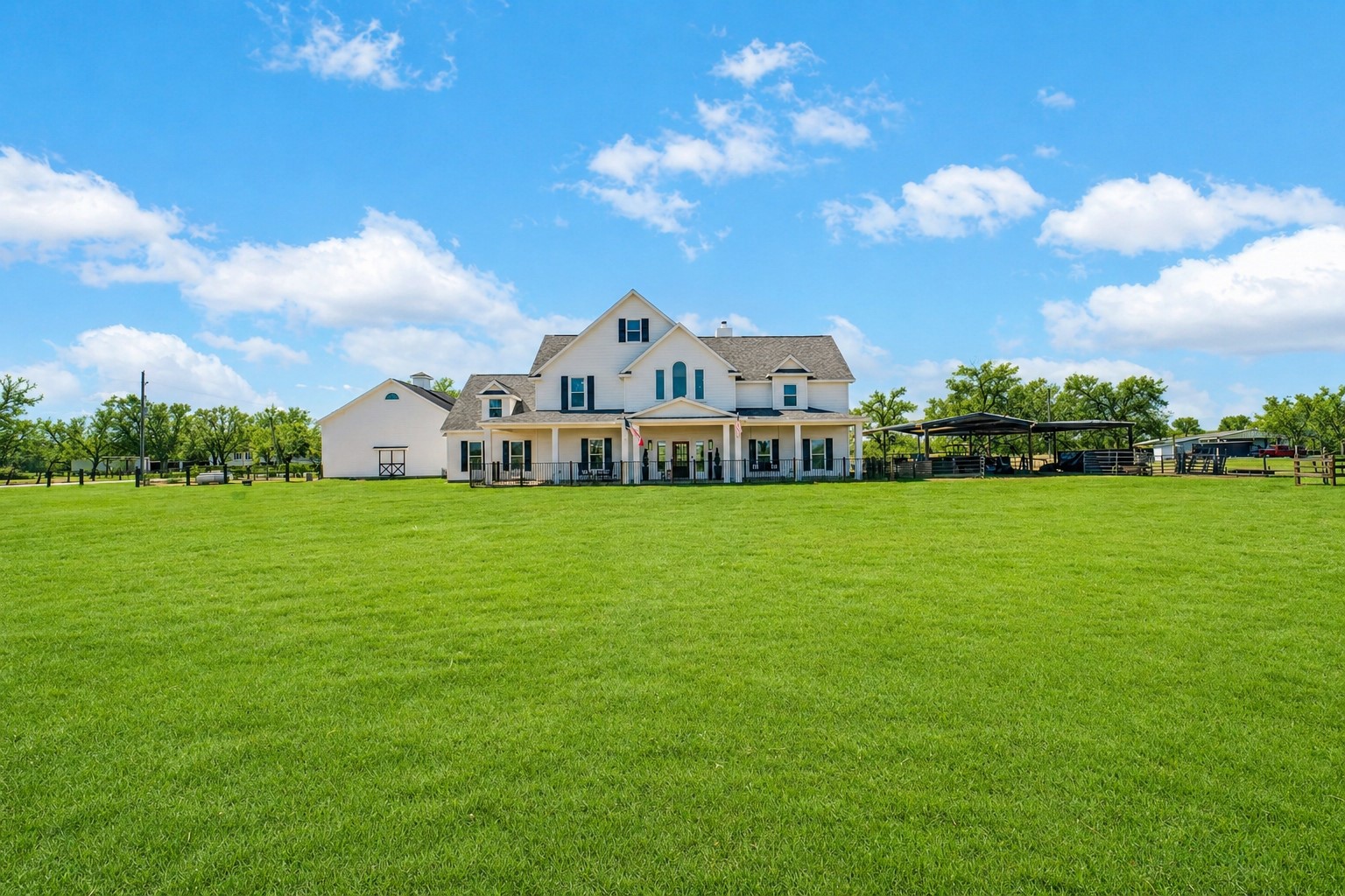 Expansive green acreage frames this charming farmhouse with wide open views.