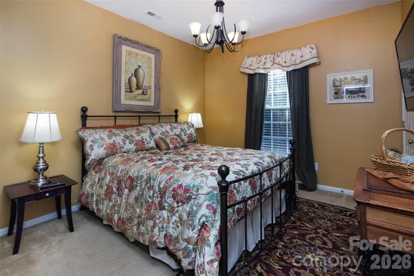 a bedroom with bed and a chandelier