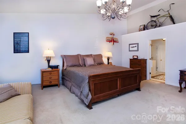 a spacious bedroom with a bed and a chandelier