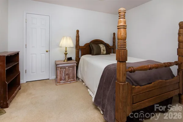 a bedroom with a bed and a lamp on dresser