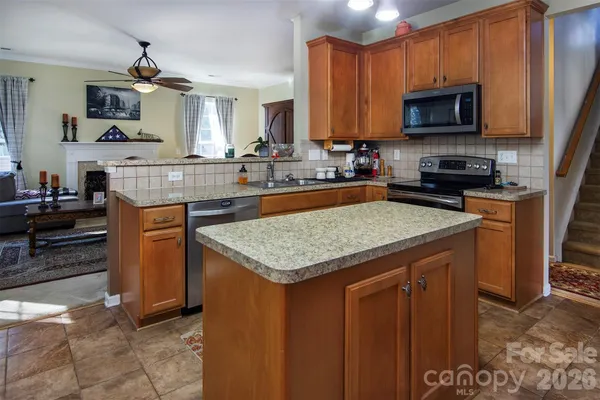 a kitchen with stainless steel appliances granite countertop a stove top oven a sink dishwasher and a microwave oven on the blue kitchen countertops