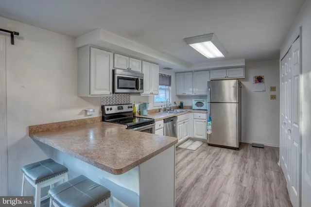 a kitchen with a refrigerator a stove a sink and a microwave