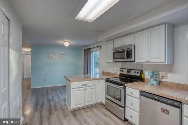 a kitchen with white cabinets stainless steel appliances and sink