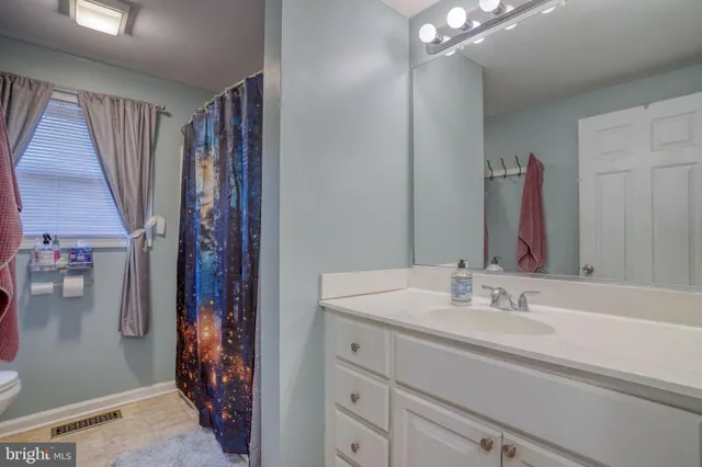 a bathroom with a sink vanity and a mirror