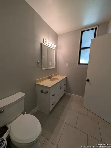 a bathroom with a toilet sink and mirror
