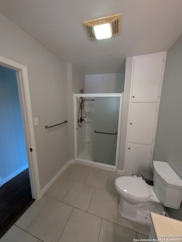 a bathroom with a toilet and a shower