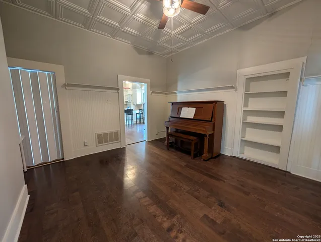 an empty room with wooden floor closet and windows