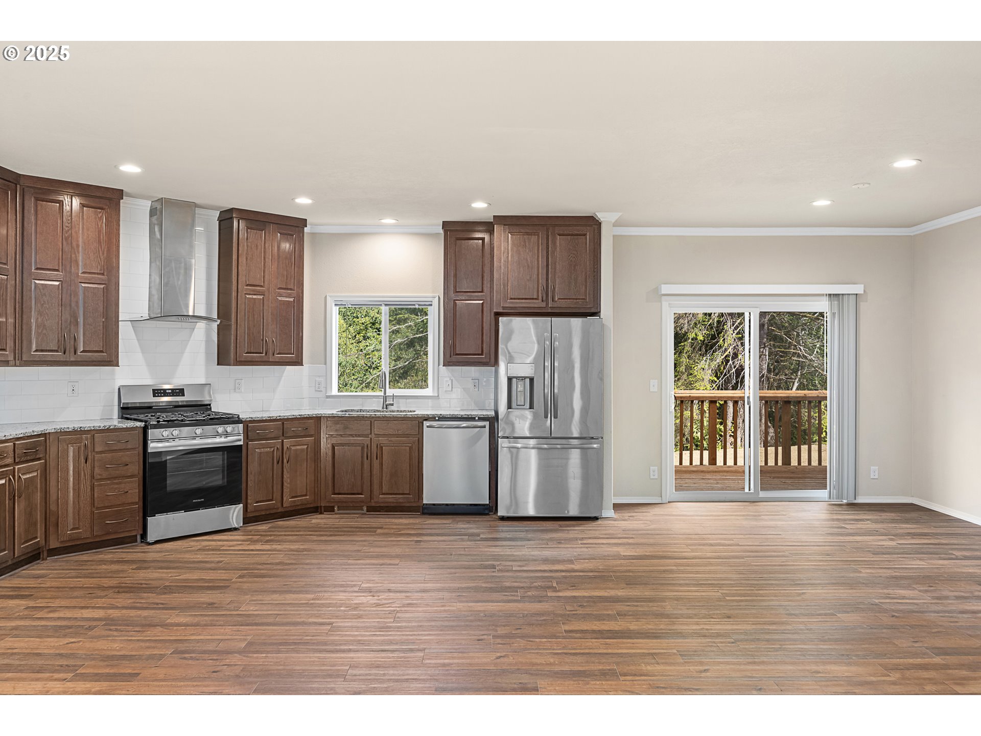352 North Falcon Street Rockaway Beach, OR 97136 - Photo 7 of 32 a kitchen with stainless steel appliances granite countertop a refrigerator a sink dishwasher a stove with wooden cabinets and wooden floor