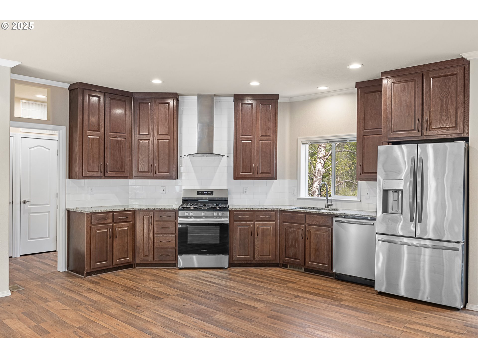 352 North Falcon Street Rockaway Beach, OR 97136 - Photo 8 of 32 a kitchen with stainless steel appliances granite countertop a refrigerator a sink dishwasher a stove with wooden floors