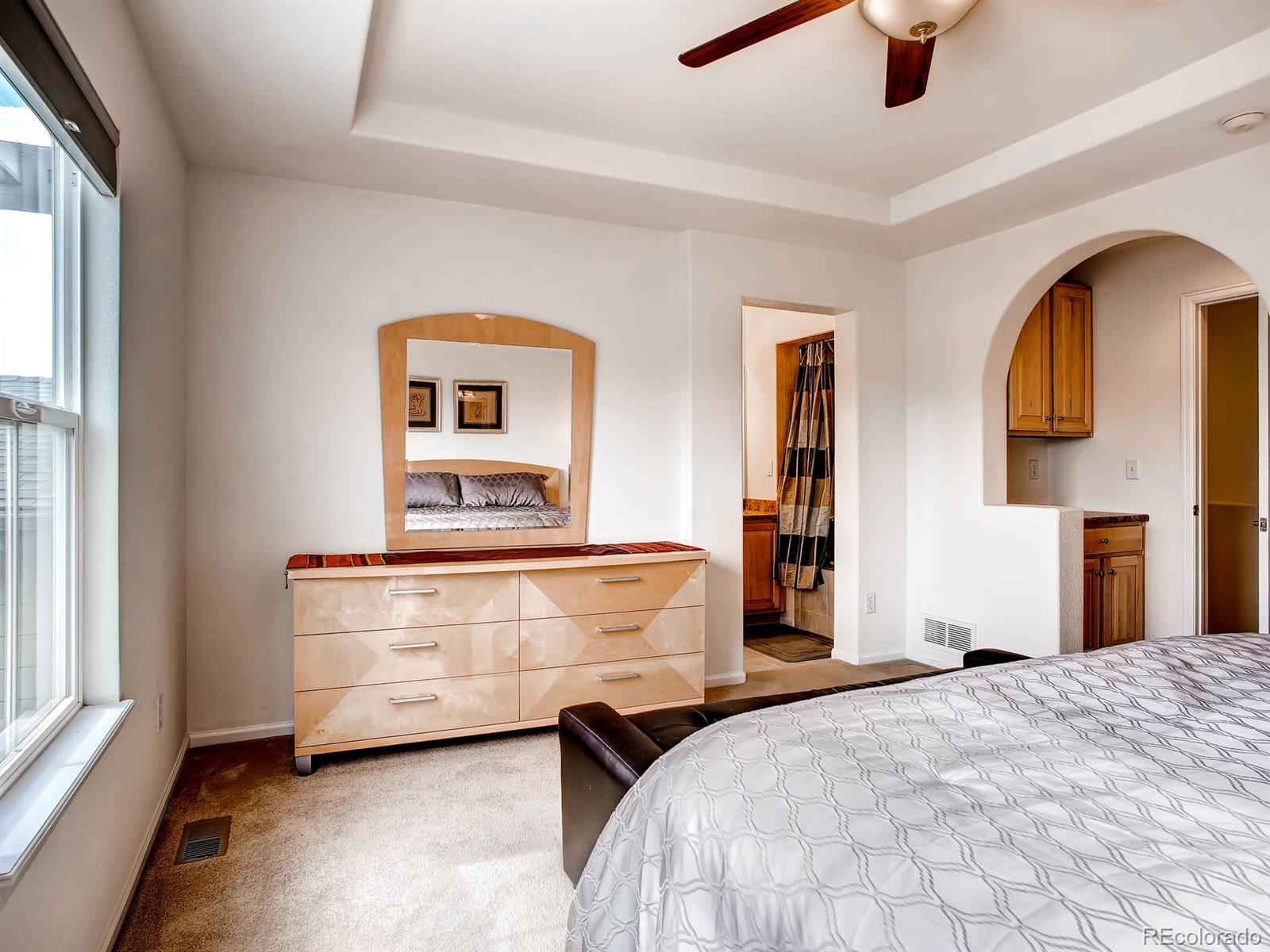 10824 Towerbridge Road Highlands Ranch, CO 80130 - Photo 15 of 33 a bedroom with a bed and a chandelier