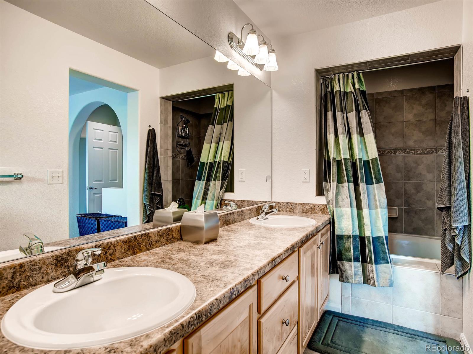 10824 Towerbridge Road Highlands Ranch, CO 80130 - Photo 16 of 33 a bathroom with a double vanity sink and a mirror