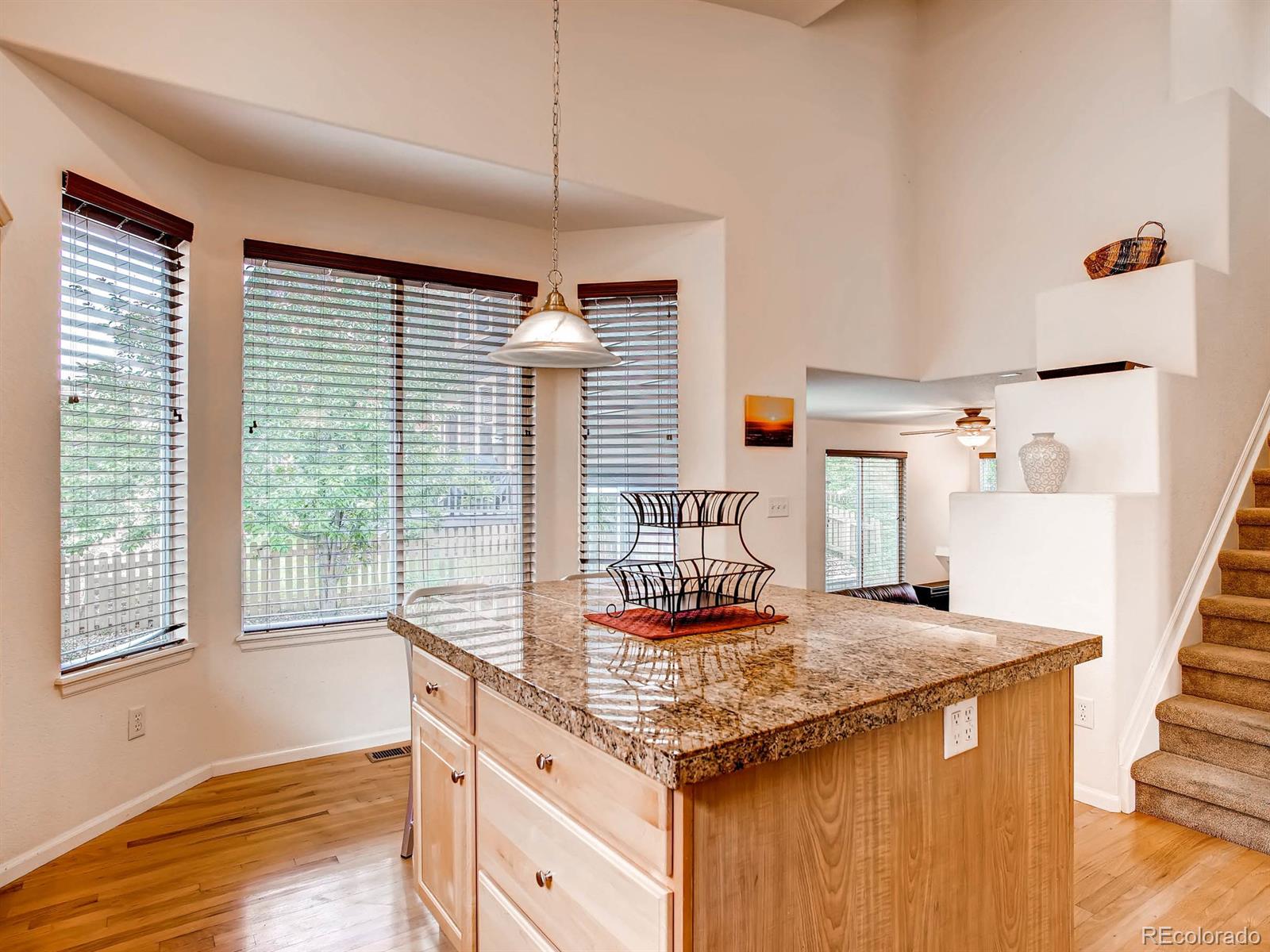 10824 Towerbridge Road Highlands Ranch, CO 80130 - Photo 7 of 33 a kitchen island with granite countertop a stove and a sink
