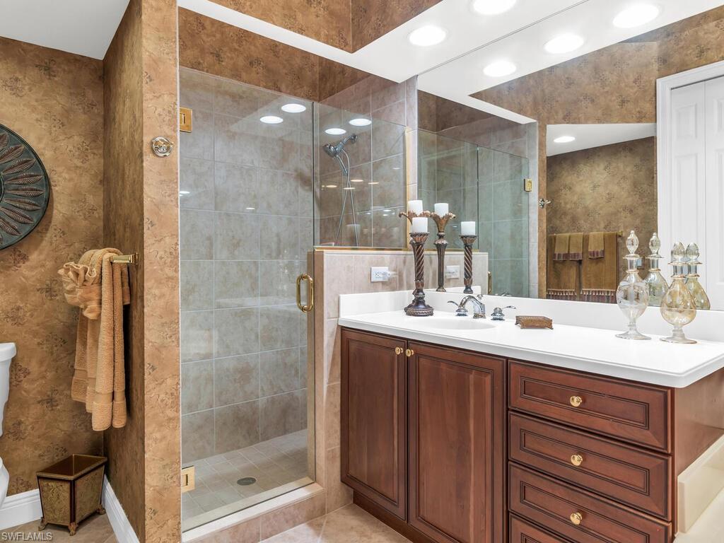 7869 Hawthorne Drive, Unit 303 Naples, FL 34113 - Photo 25 of 50 Bathroom with tile patterned flooring, vanity, and an enclosed shower