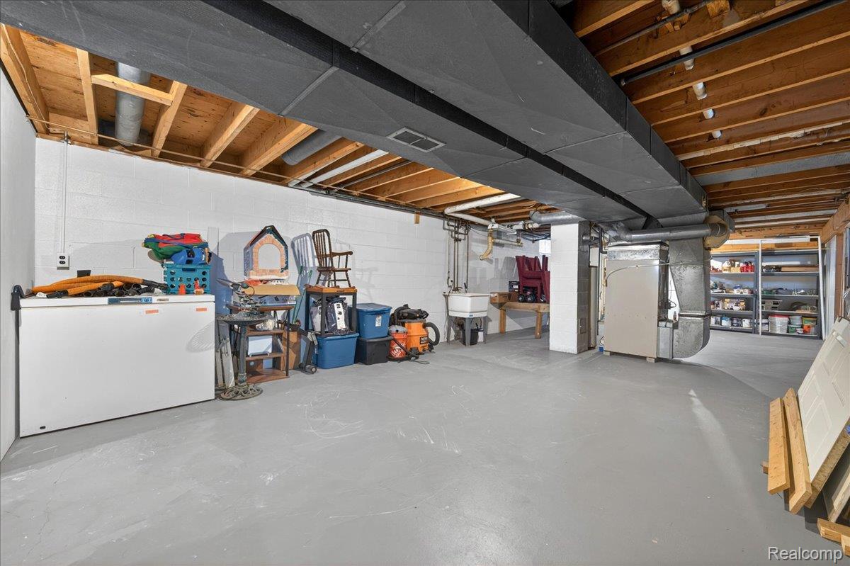 4049 Slattery Road North Branch, MI 48461 - Photo 35 of 45 Unfinished basement featuring white fridge and heating unit