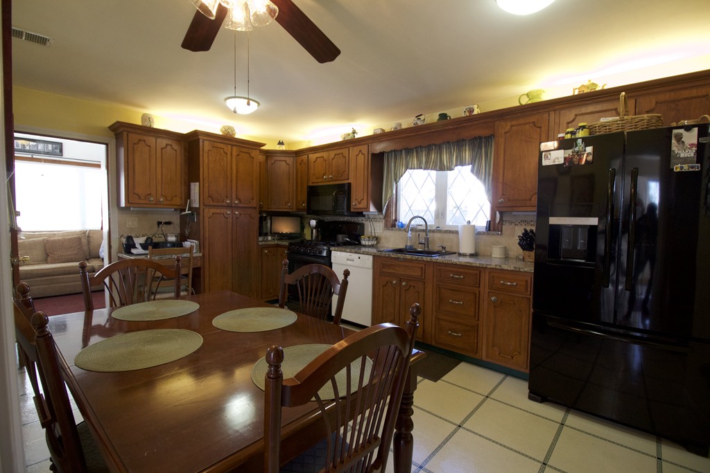41 Lodge Road Newton, MA 02465 - Photo 5 of 25 a kitchen with stainless steel appliances granite countertop a sink a stove a refrigerator a dining table and chairs with wooden floor