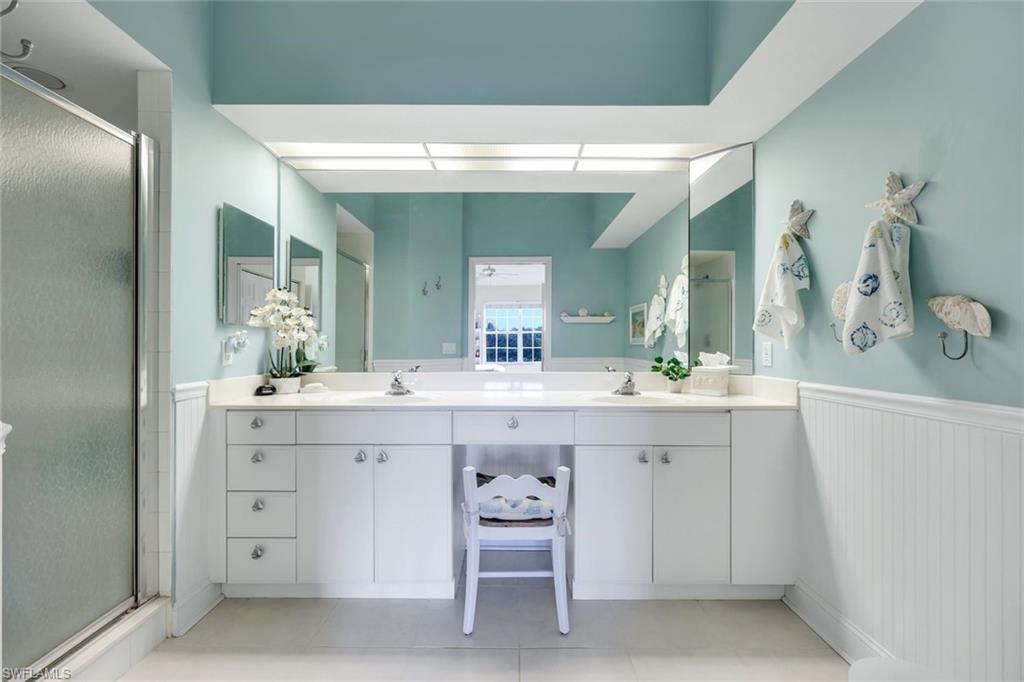 10801 Halfmoon Shoal Road, Unit 202 Estero, FL 34135 - Photo 10 of 45 Primary bathroom features a shower, double vanity and seated vanity area.