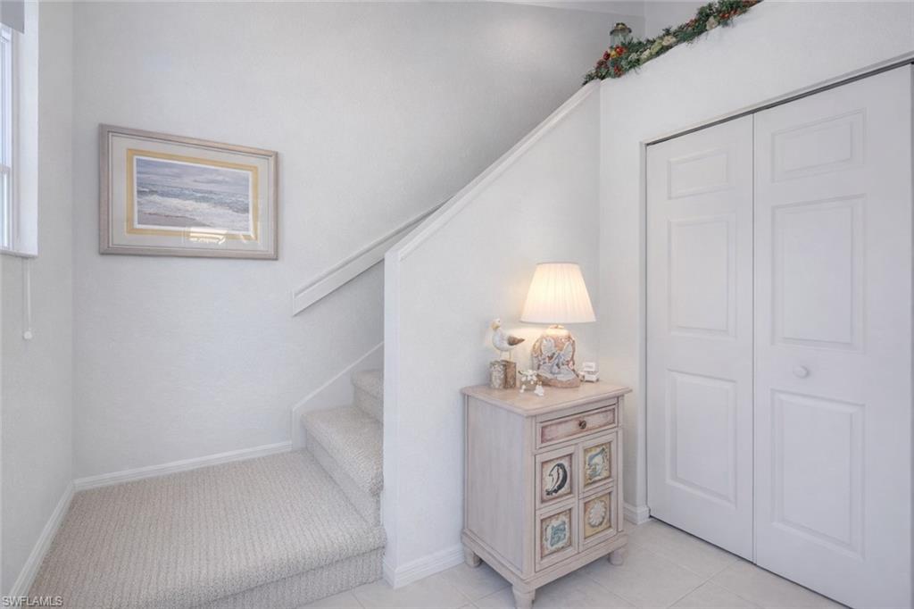 10801 Halfmoon Shoal Road, Unit 202 Estero, FL 34135 - Photo 2 of 45 (Virtual wall color change and flooring upgrades) Entry way with virtual carpeted staircase and coat closet.
