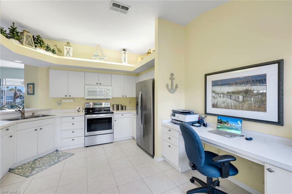 10801 Halfmoon Shoal Road, Unit 202 Estero, FL 34135 - Photo 21 of 45 Kitchen features stainless steel refrigerator and oven, and pantry, as well as an office nook with plenty of light!