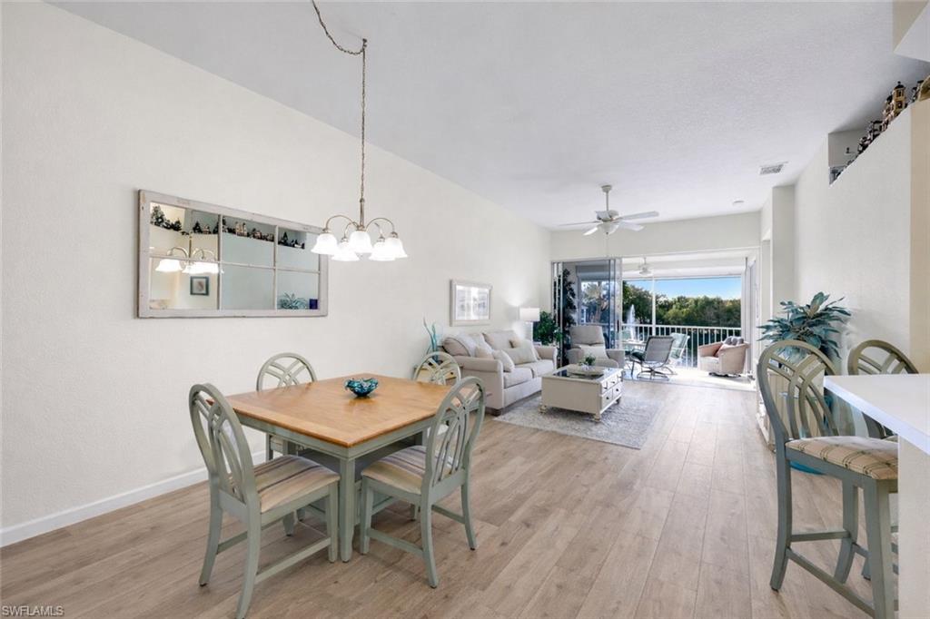 10801 Halfmoon Shoal Road, Unit 202 Estero, FL 34135 - Photo 41 of 45 (Virtual wall color change and flooring upgrades) Dining area, living room and counter seating at the kitchen bar in a spacious open floor plan.