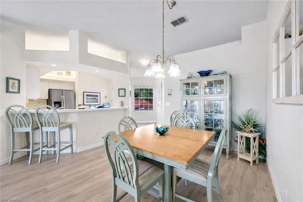 10801 Halfmoon Shoal Road, Unit 202 Estero, FL 34135 - Photo 42 of 45 (Virtual wall color change and flooring upgrades) Dining area, living room and counter seating at the kitchen bar in a spacious open floor plan.