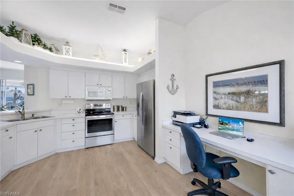 10801 Halfmoon Shoal Road, Unit 202 Estero, FL 34135 - Photo 5 of 45 (Virtual wall color change and flooring upgrades) Kitchen features stainless steel refrigerator and oven, and pantry, as well as an office nook with plenty of light!