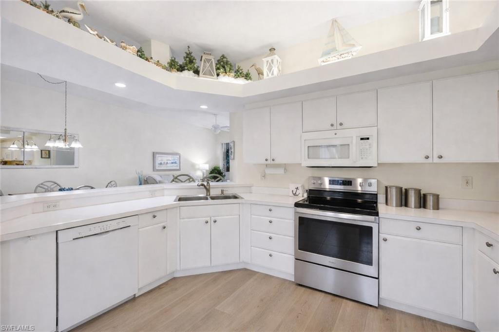 10801 Halfmoon Shoal Road, Unit 202 Estero, FL 34135 - Photo 6 of 45 (Virtual wall color change and flooring upgrades) Kitchen features stainless steel refrigerator and oven, and pantry, as well as an office nook with plenty of light!