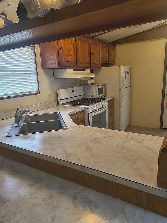 1250 Winn Road Bowie, TX 76230 - Photo 16 of 40 a kitchen with stainless steel appliances granite countertop a sink a stove and a refrigerator with granite countertops