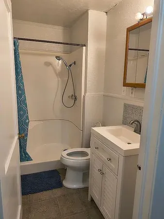 a white toilet sitting in a bathroom next to a sink