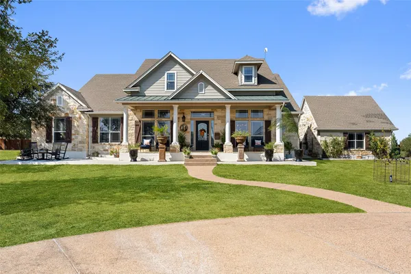 a front view of a residential houses with yard and green space