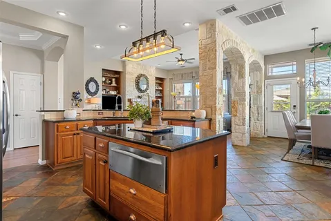 a kitchen with stainless steel appliances granite countertop a sink a stove and a wooden floors