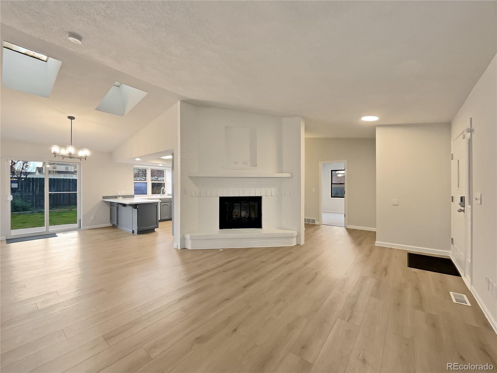 14 Maple Drive Frederick, CO 80530 - Photo 3 of 20 an empty room with wooden floor fireplace and windows