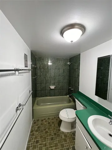 a bathroom with a sink a toilet a mirror and bathtub