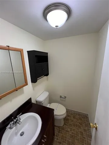 a bathroom with a sink a toilet and mirror