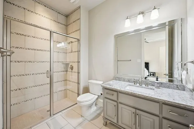 a bathroom with a granite countertop sink a toilet and shower