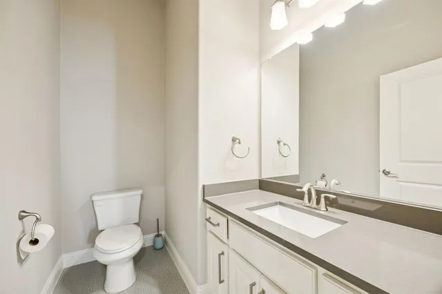 a bathroom with a granite countertop sink mirror and a toilet