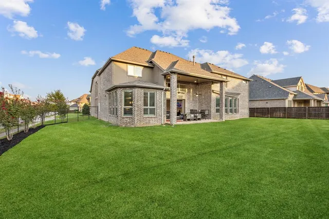 a view of a house with a big yard and large trees
