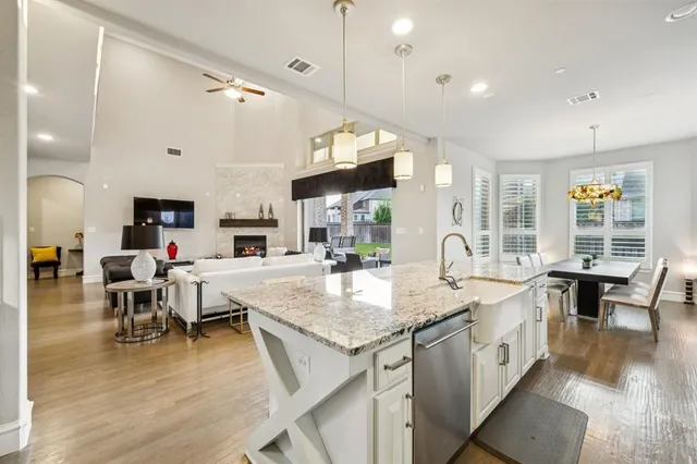 a large kitchen with lots of counter space a sink and living room view