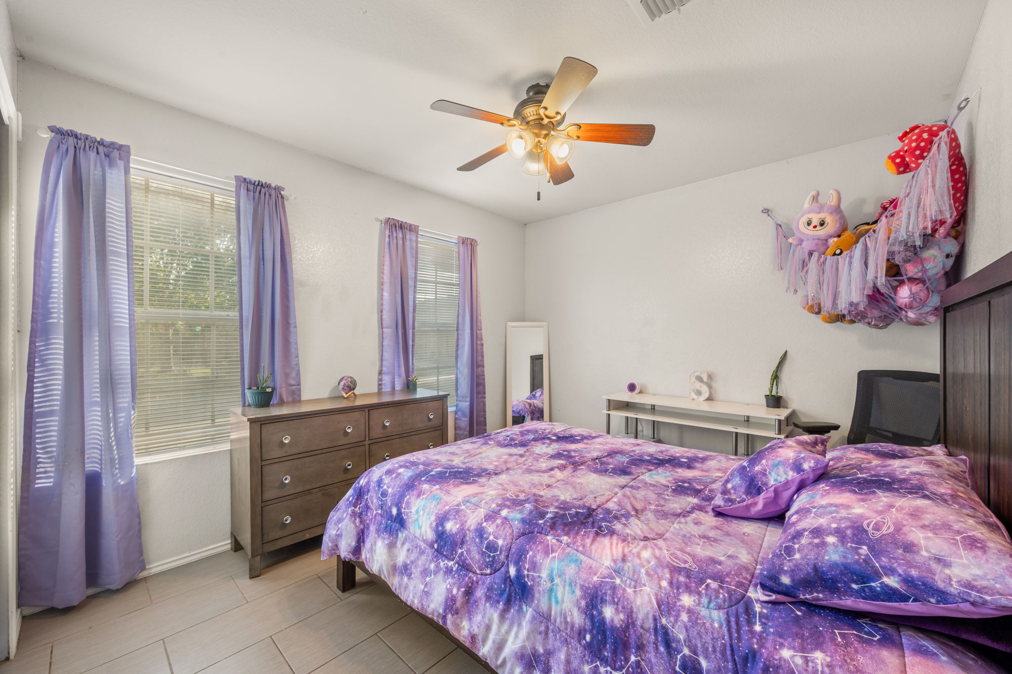 14206 Varrelman Street Austin, TX 78725 - Photo 17 of 27 a bedroom with a large bed and a chandelier