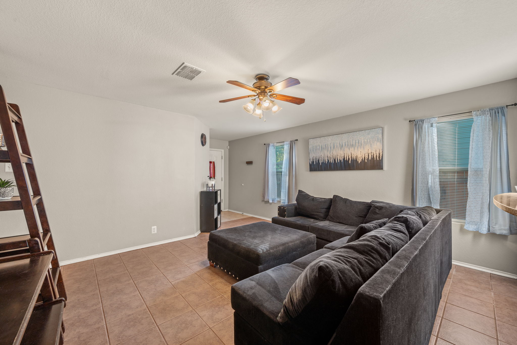 14206 Varrelman Street Austin, TX 78725 - Photo 6 of 27 a living room with furniture and a chandelier